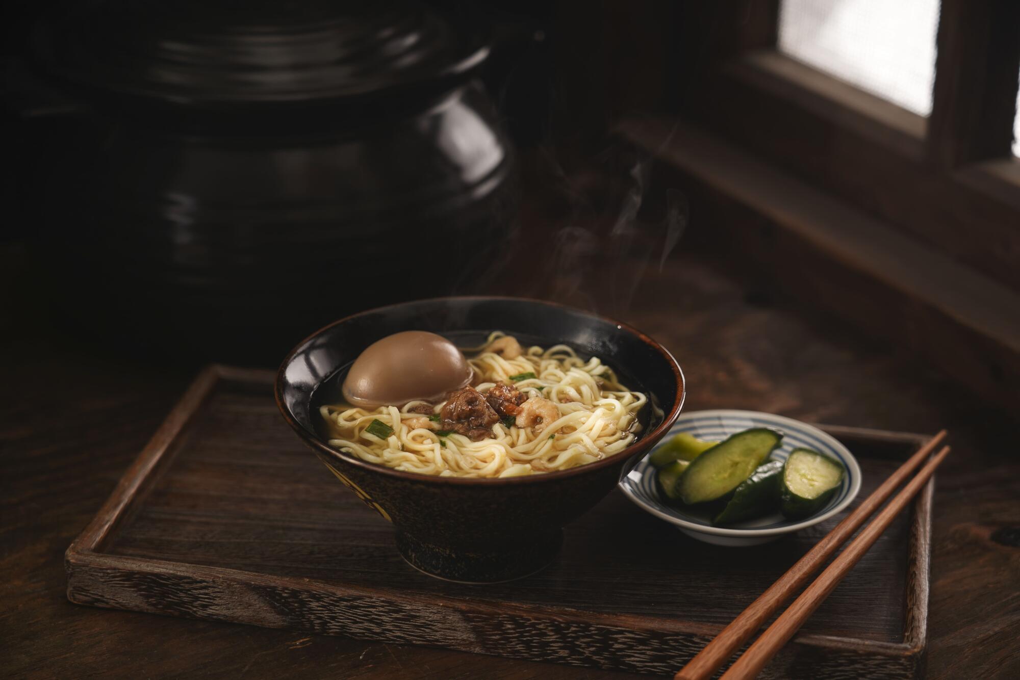 Bowl of perfectly cooked ramen noodles with soy egg and cucumbers showing springy, light texture.