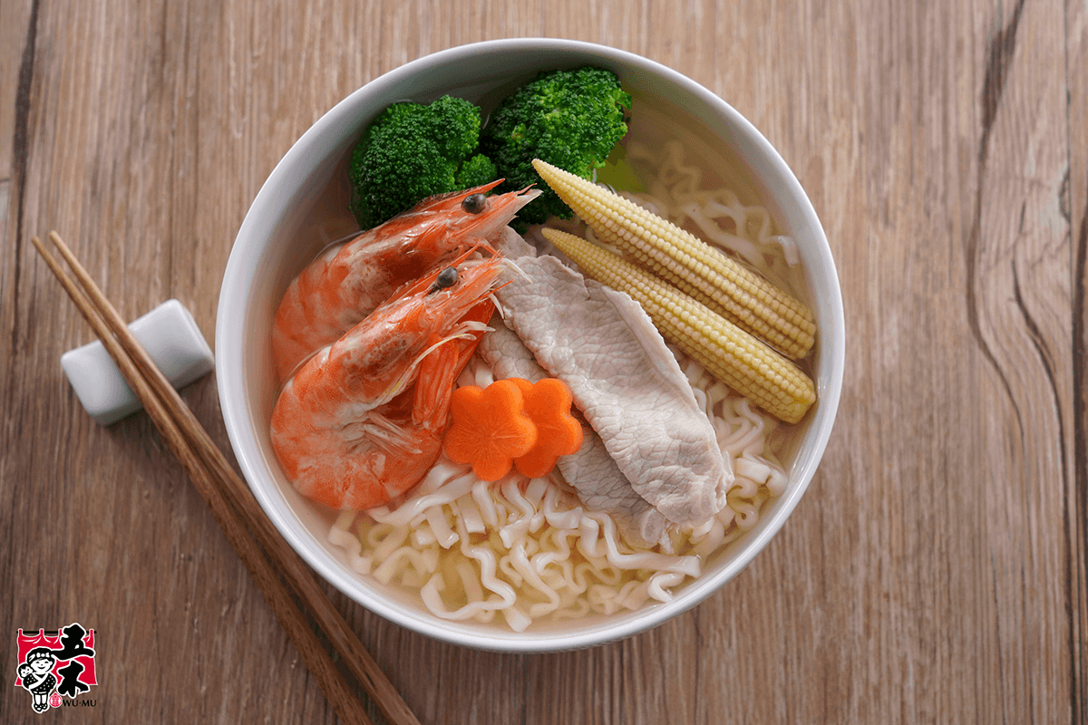 A bowl of SING-LIN FOODS ramen noodles served with shrimp, pork slices, broccoli, and baby corn.
