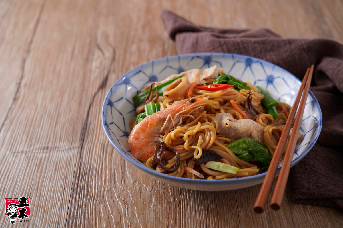 Stir-fried yellow noodles with shrimp, sliced pork, and vegetables.