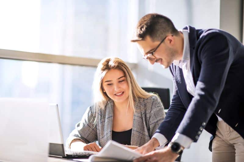 smart contracts​: homem e mulher analisando contrato no escritório