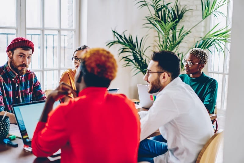 Profissionais reunidos no escritório para analisar informações usando tecnologia para gestão de associações.