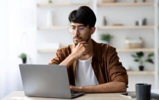 Customer lifetime value: homem pensativo trabalhando no computador.