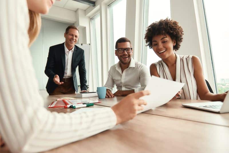 grupo de mulheres e homens sorriem enquanto falam sobre a renovação de contrato em uma associação