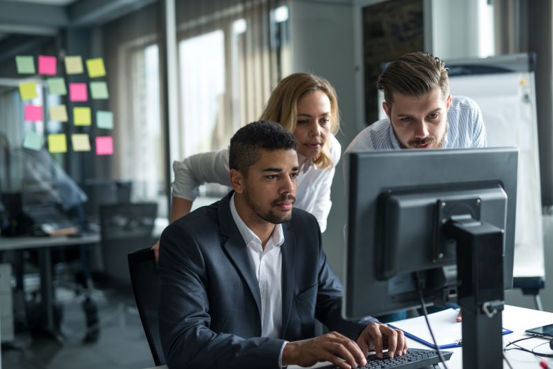 Automação de processos​: equipe de contadores olhando tela de computador.