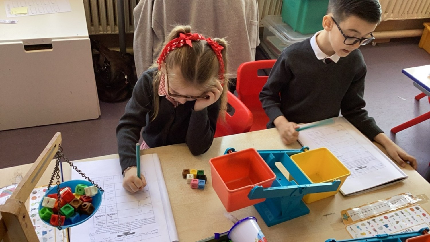 Measuring weight of objects around the classroom using a balance scale and cubes. We were able to make predictions and then record our results.