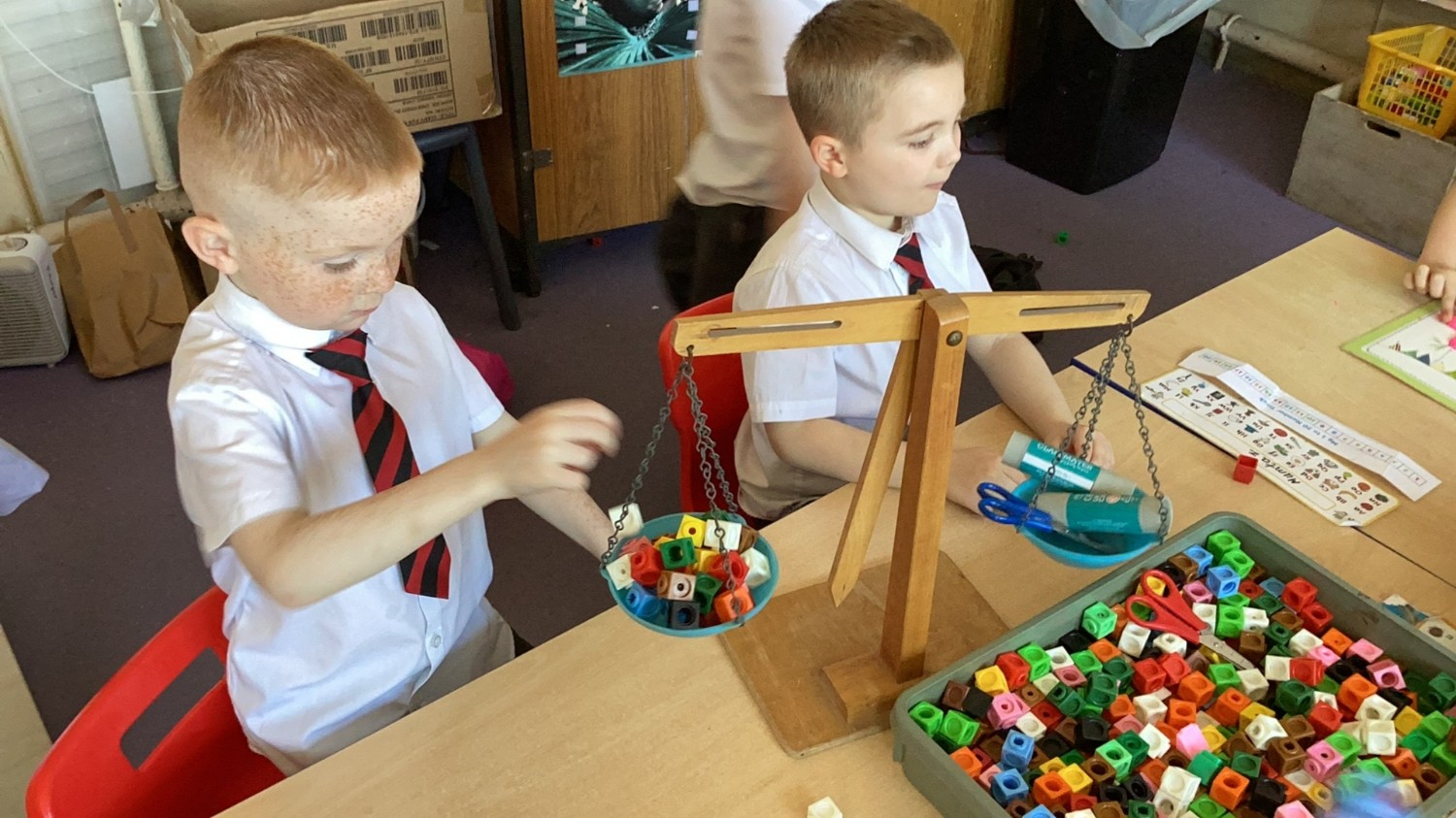 Investigating how to measure objects using a balance scale and cubes.