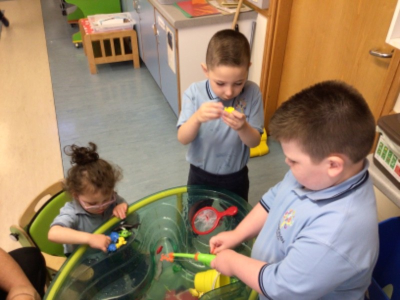 We're catching and counting fish together at the water tray.