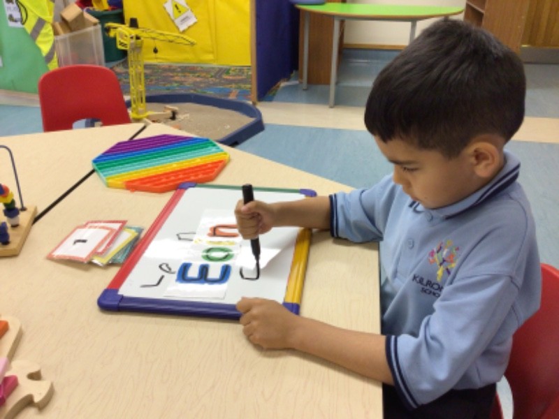 I'm showing independence in literacy activities, by copying my friends' names.