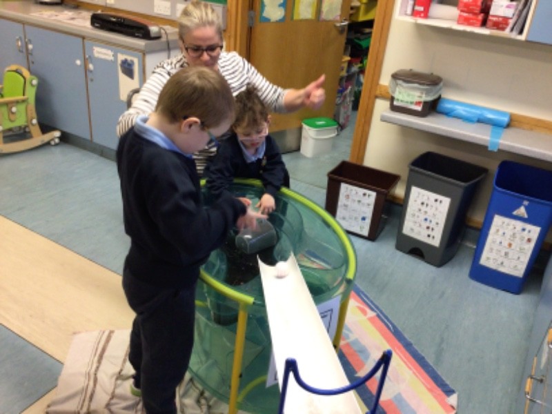 A lovely moment shared at the water tray, exploring gravity by pouring water down the drain pipe, and waiting to catch the Incy Wincy Spider!