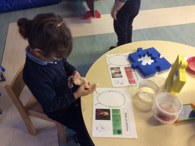 Using the play dough to make emotion faces.