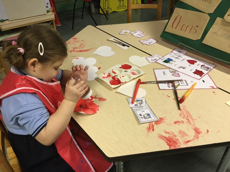 Painting and putting red glitter onto my friends heart.