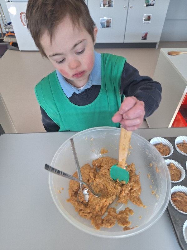 Shane is mixing his carrot and orange muffin mixture.