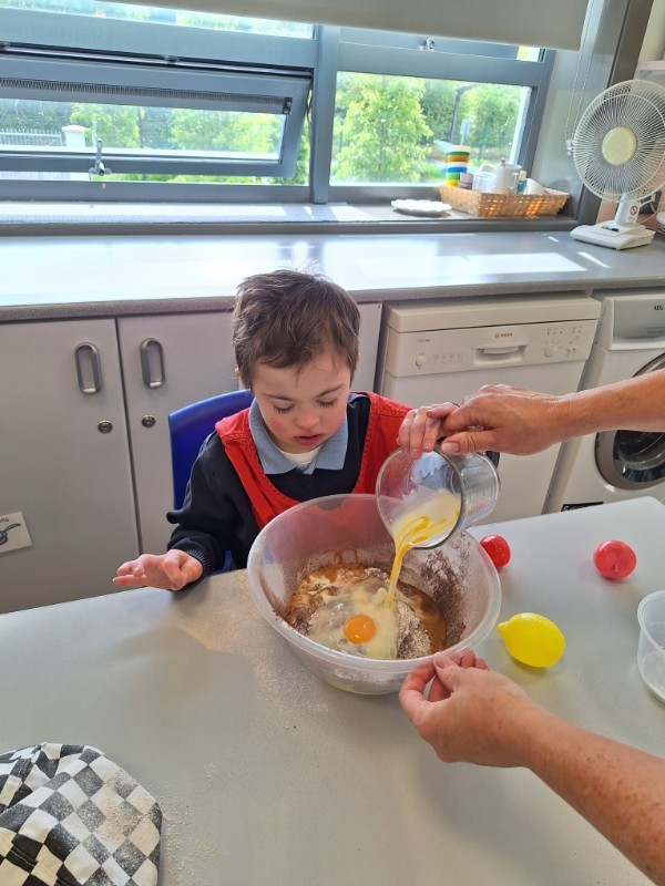 Shane is helping to add ingredients into the bowl.