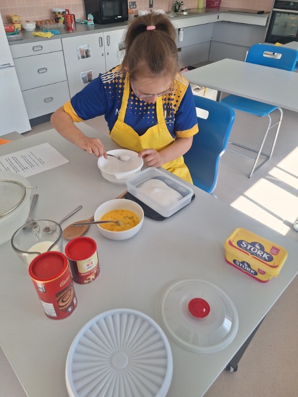 Patricia is measuring the caster sugar carefully.
