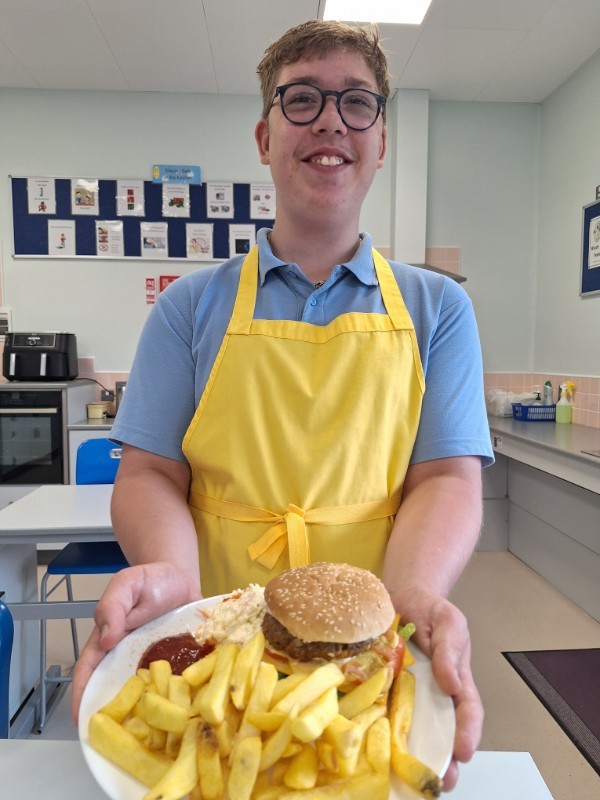 Gustas is very proud of his homemade burger.