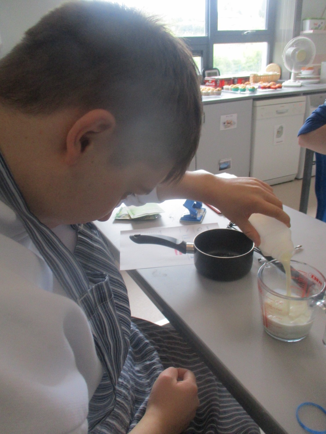 Nathan is in charge of making the white sauce so he measures the milk out carefully.