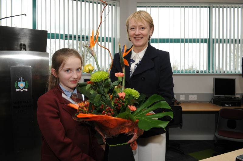 Representing the future of St Patrick's High School, the youngest girl in the school - Shona Marie Farrell - presents a gift to Ms Pat McGuckian, School Principal at the recent opening of Ionad an tSolais.