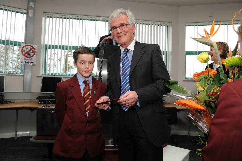 The youngest boy in the school, John Joe Nugent, presents a gift to Mr Pat McAleavey, former School Principal at the recent opening of Ionad an tSolais.