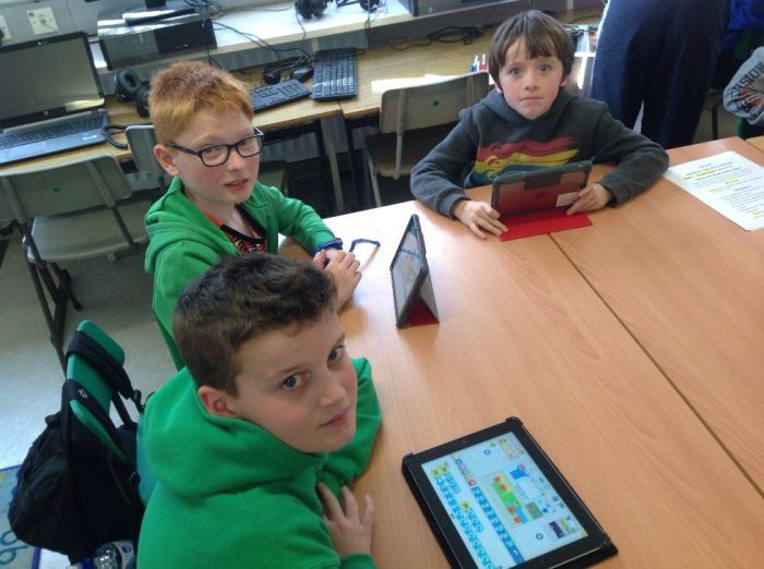 Shea, Eoin and Patrick programming their characters on Scratch Jr. app