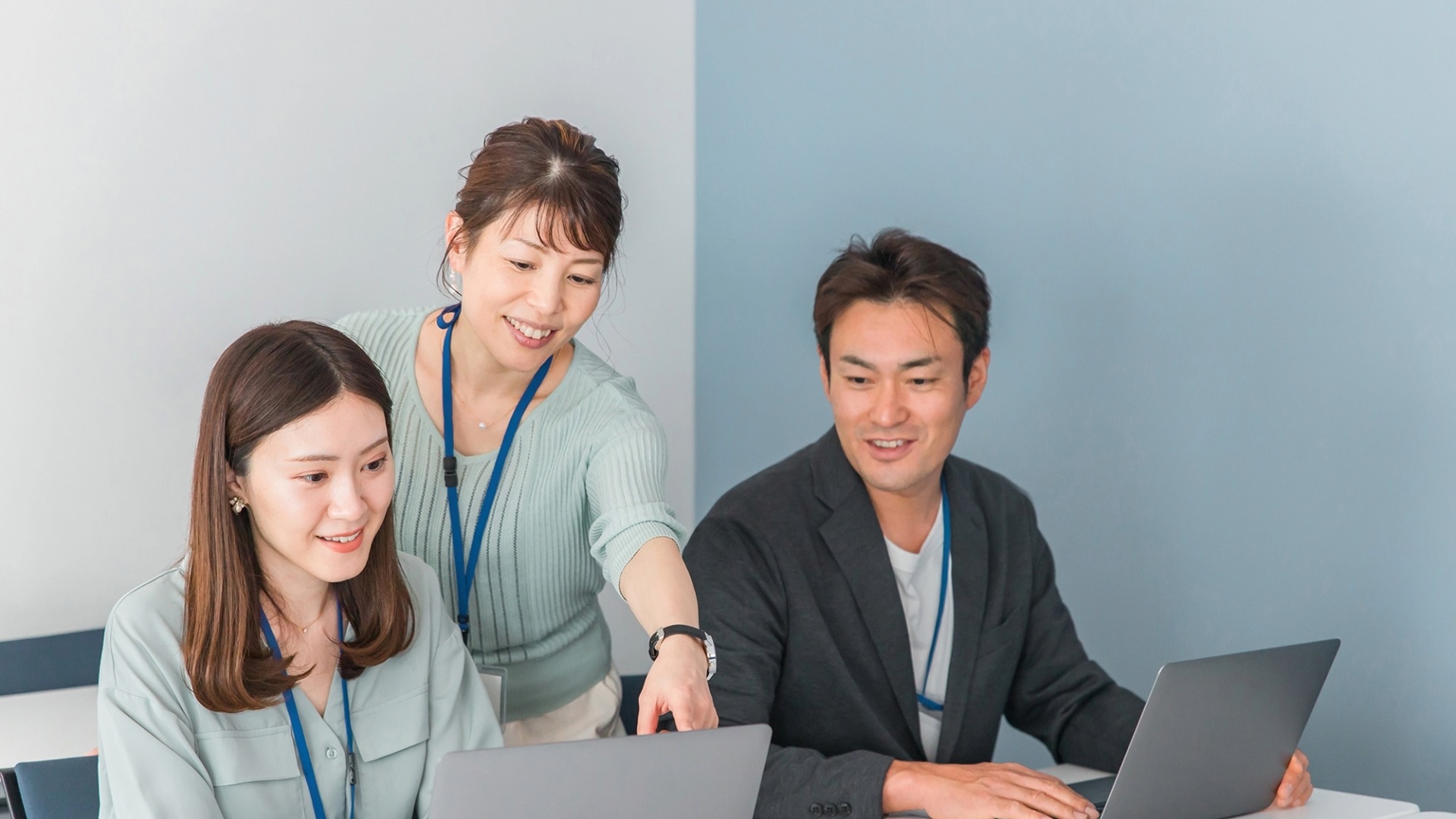 最新のGEO対策や生成AIエンジンのアルゴリズムについて、パソコンを見ながら情報を共有し合うチーム