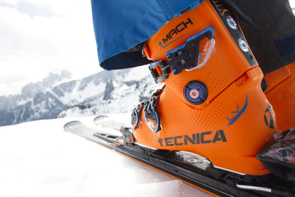 Orange ski boots clipping in to skis
