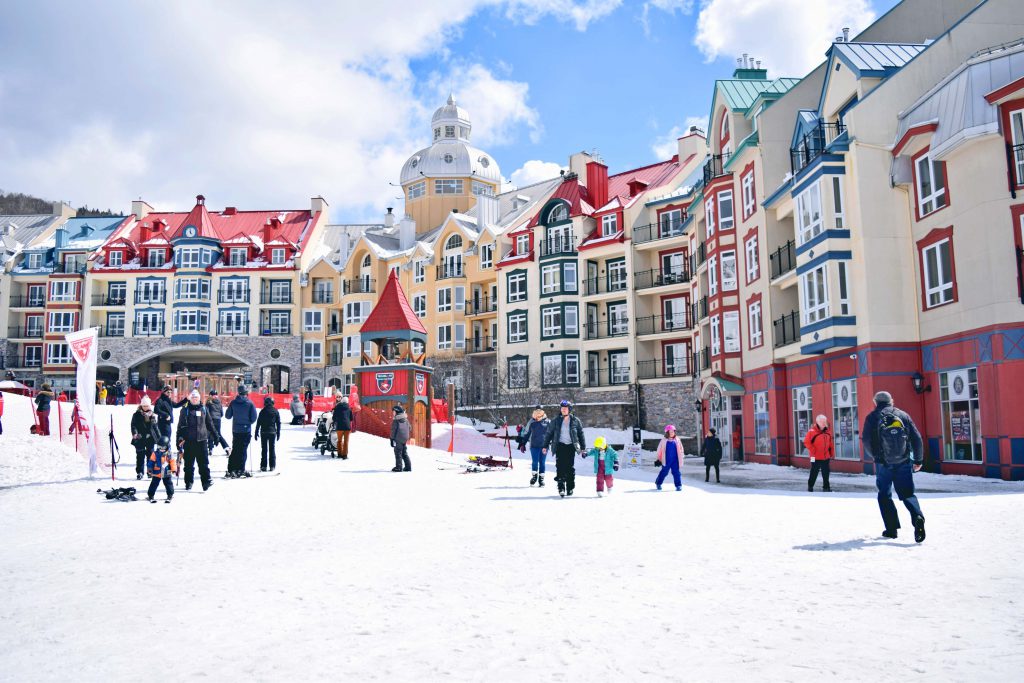 Group of people wandering around ski resort vilalge