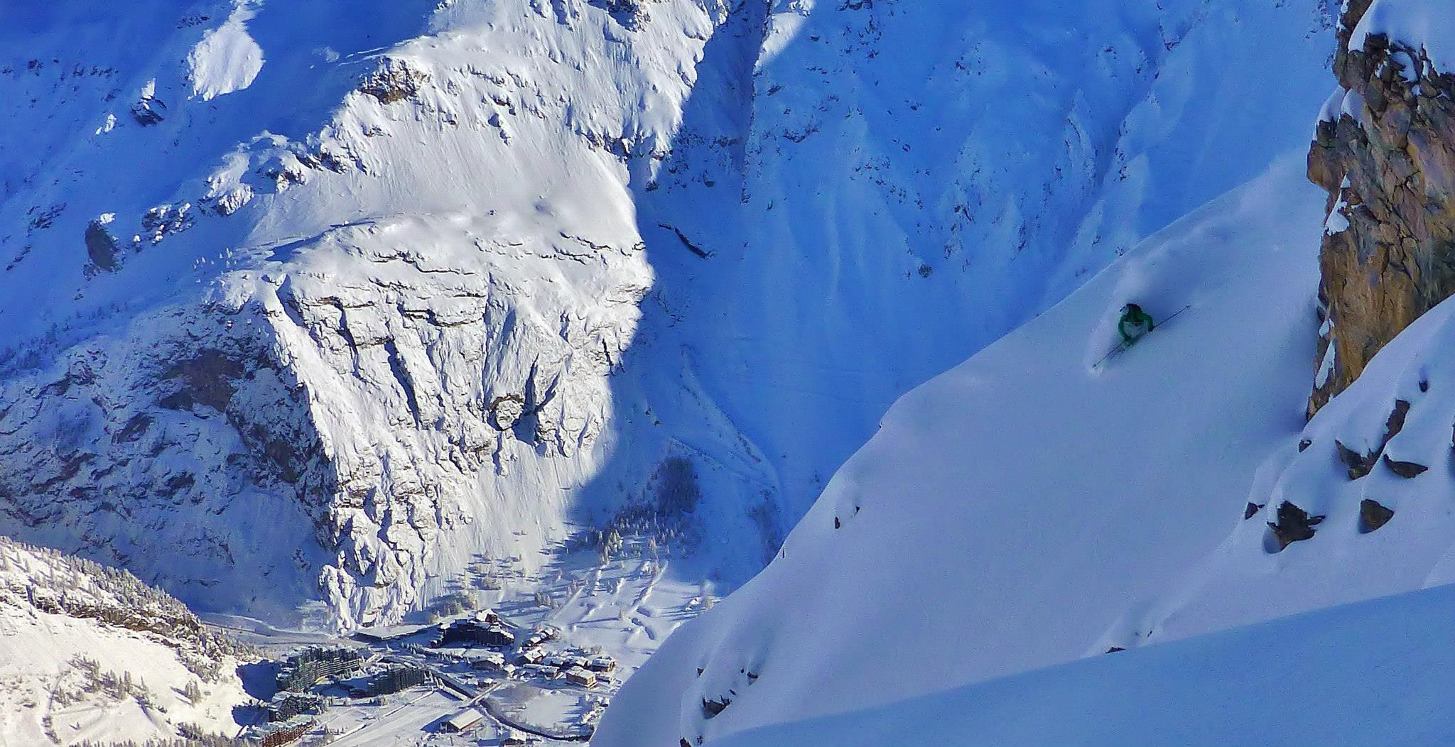 Skier making big powder turn in entrance to Table couloir Val d'Isere