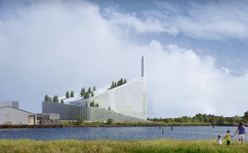 CopenHill, a stylish waste incinerator with a ski run on the sloped roof sits in front of a lake