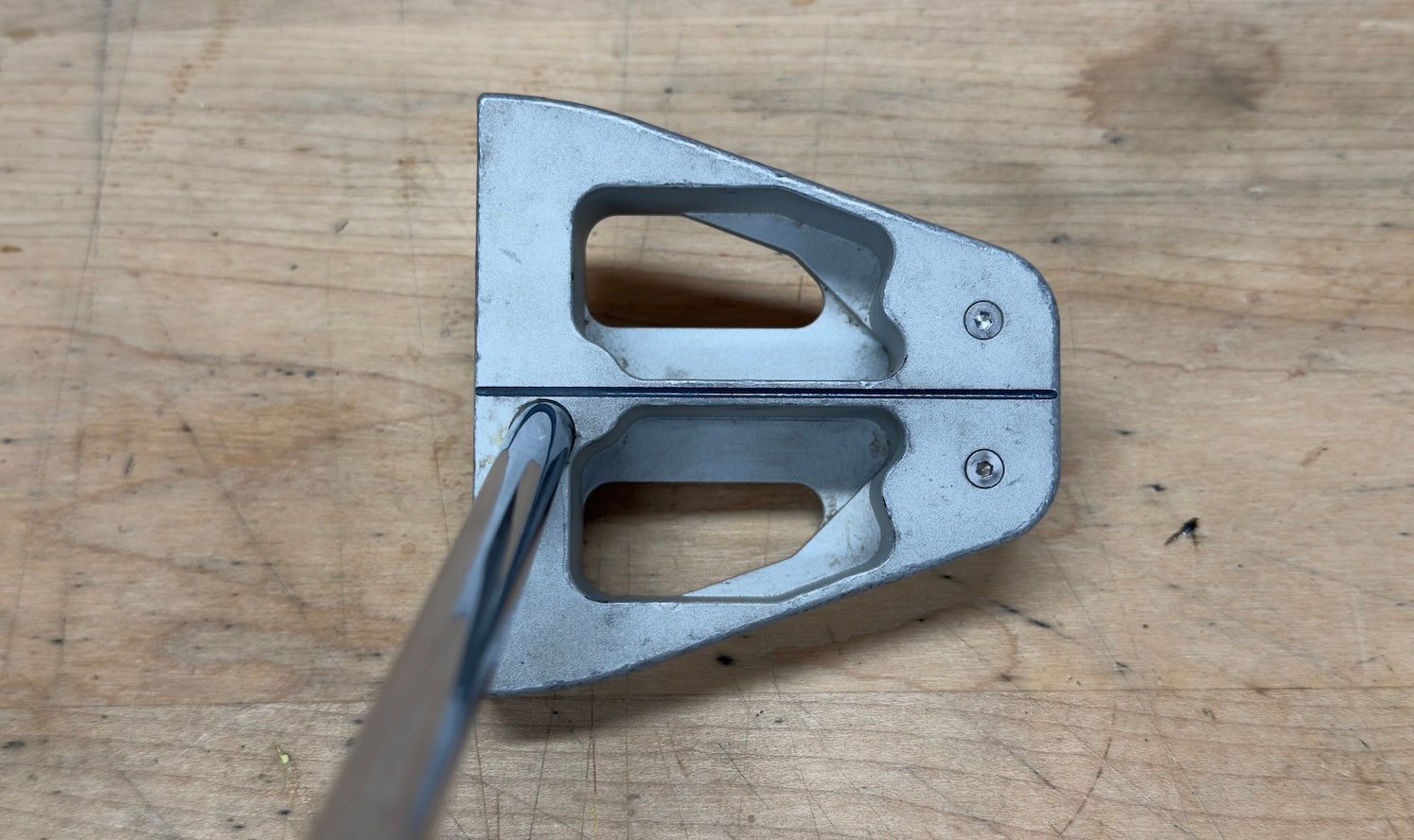 Silver metal tool with two open sections, a central seam, and a thin blade inserted.