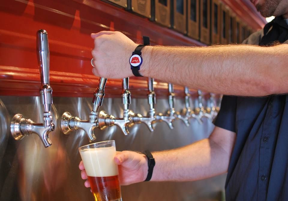 Sirviendo cerveza con los stickers personalizados en las pulseras RFID