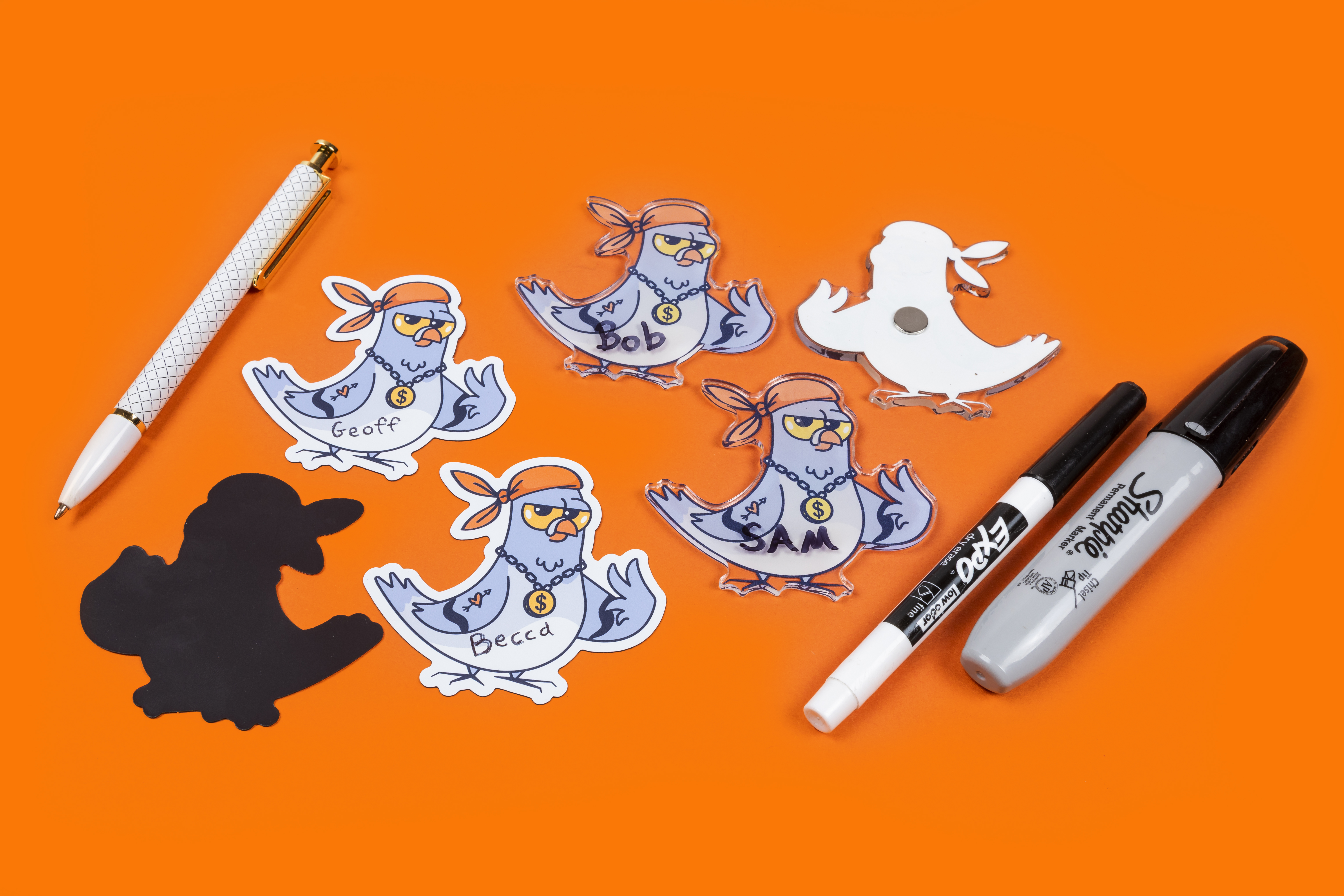 exemples de magnets standards et acryliques avec écriture au stylo et au marqueur sur fond orange