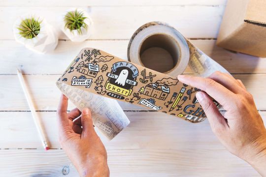 Brown kraft packaging tape with a full color doodle design on it.