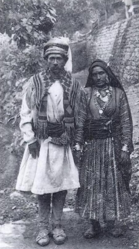 A man dressed in achkan with dora or sash wrapped around the waist.