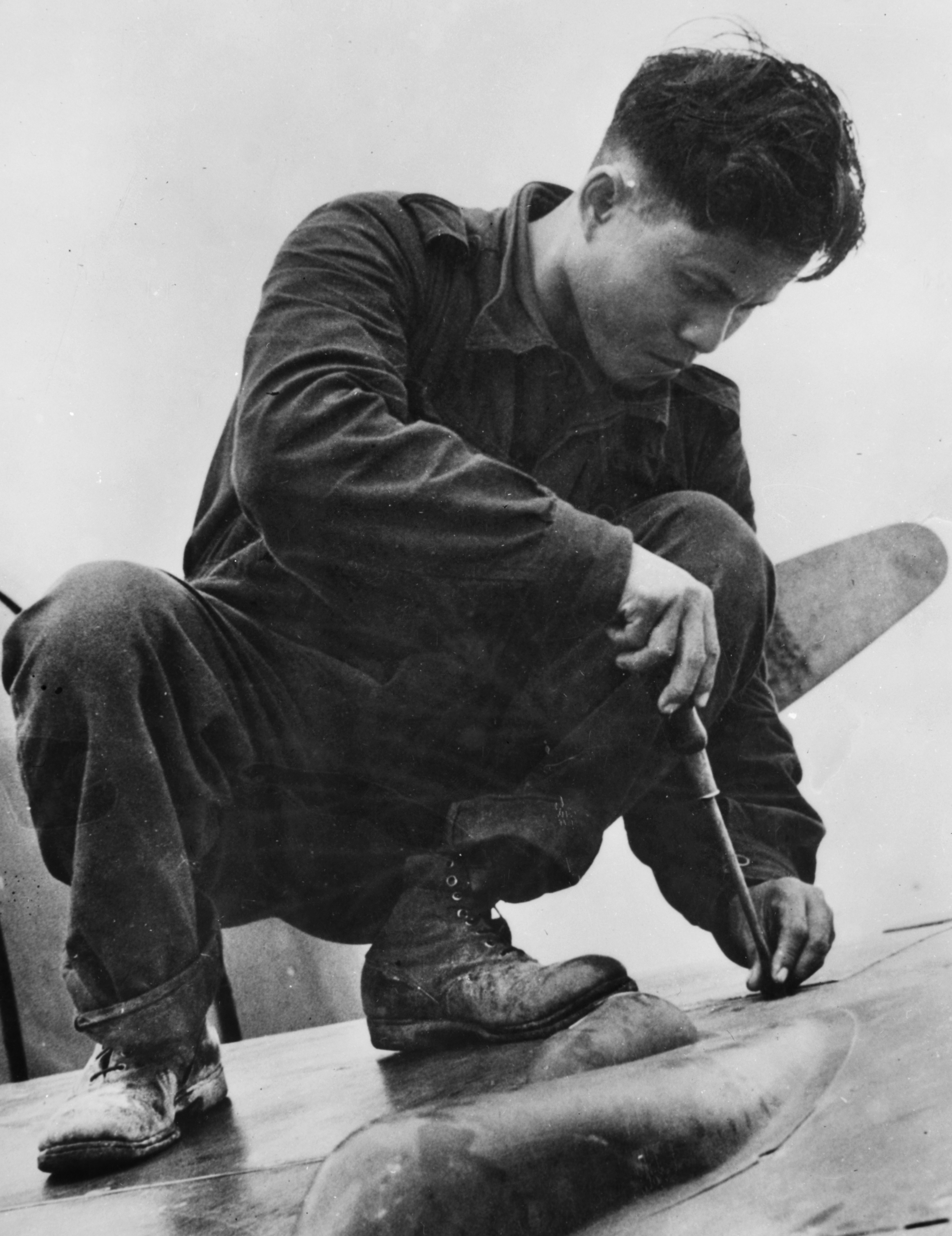 A Javanese engineer closes one of the gun bay doors on a Dutch Buffalo, January 1942.
