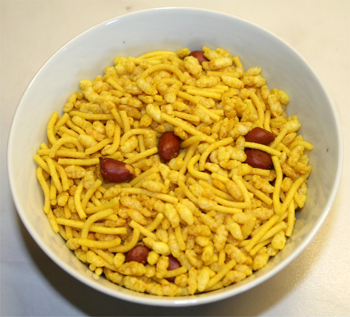 A bowl of sev mamra, consisting of puffed rice, peanuts and fried seasoned noodles