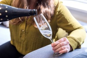 Graviertes Champagnerglas wird mit Champagner gefüllt