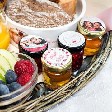 Detail of Mother's Day breakfast basket with fruit, bread and little jars of jam