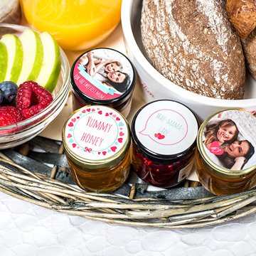 Detail of breakfast basket with fruit, bread and little jars of jam