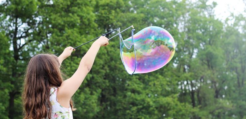 Jeune fille jouant avec des bulles de savon géantes