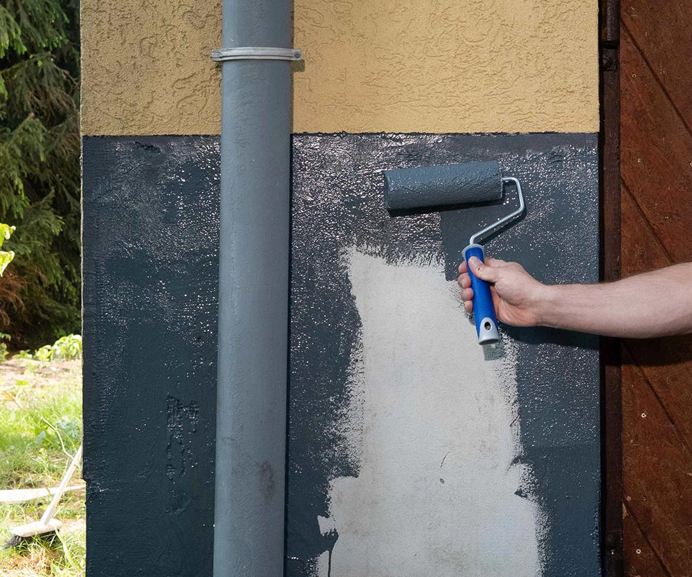 malowanie przyziemia domu grafitową Papą w Płynie