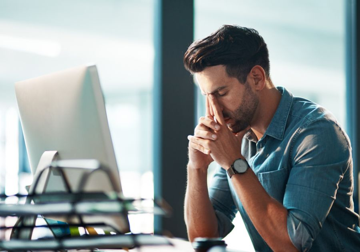 a working man with brain fog sitting at a computer