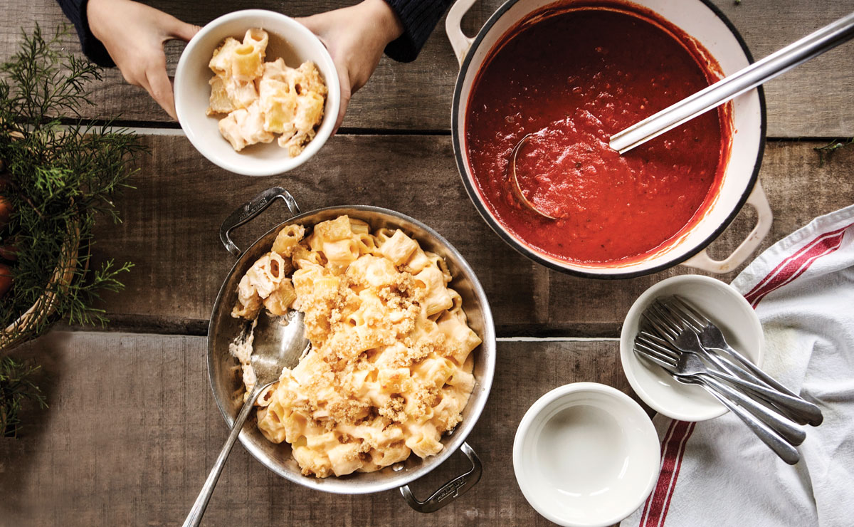 a pot of macaroni and cheese with a pot of red gravy