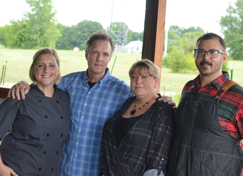 four people standing in front of a window at a restaurant