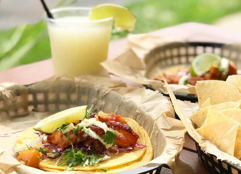 a basket of tacos and margaritas at taco buddha