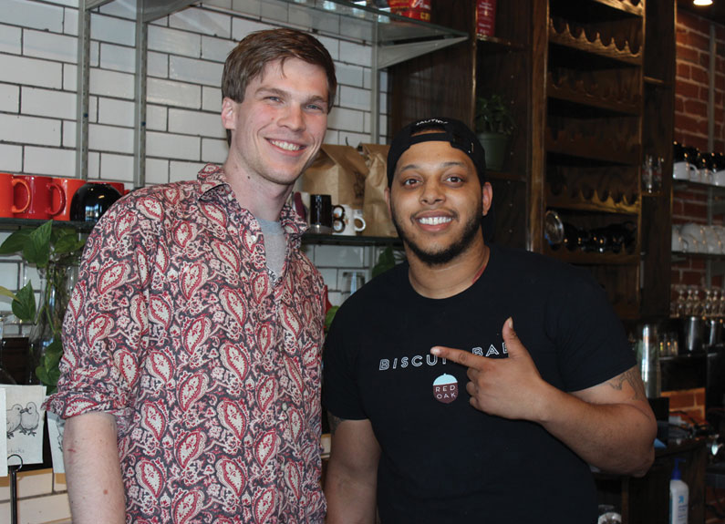 two men standing behind a bar at a restaurant