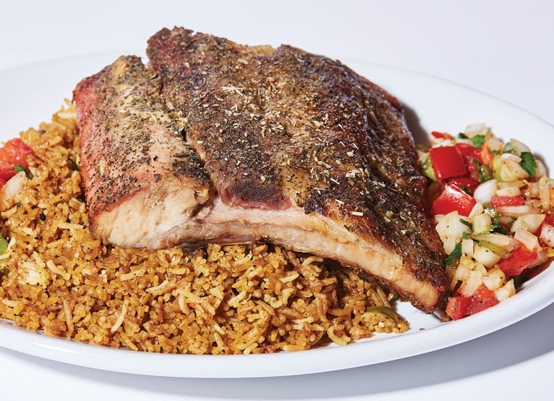 roasted pork ribs atop rice at simba ugandan cuisine in st. louis