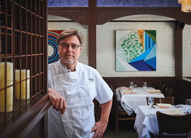 chef leaning against a wall in his restaurant