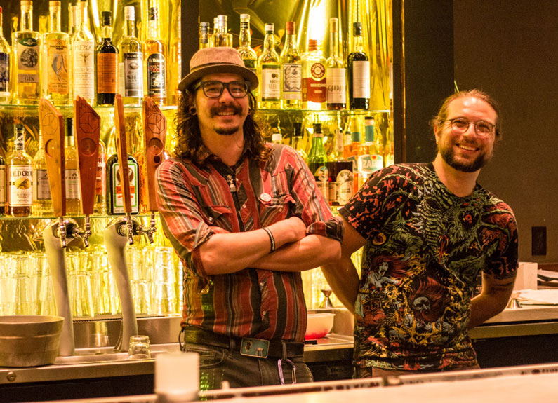 two men with moustaches behind a bar