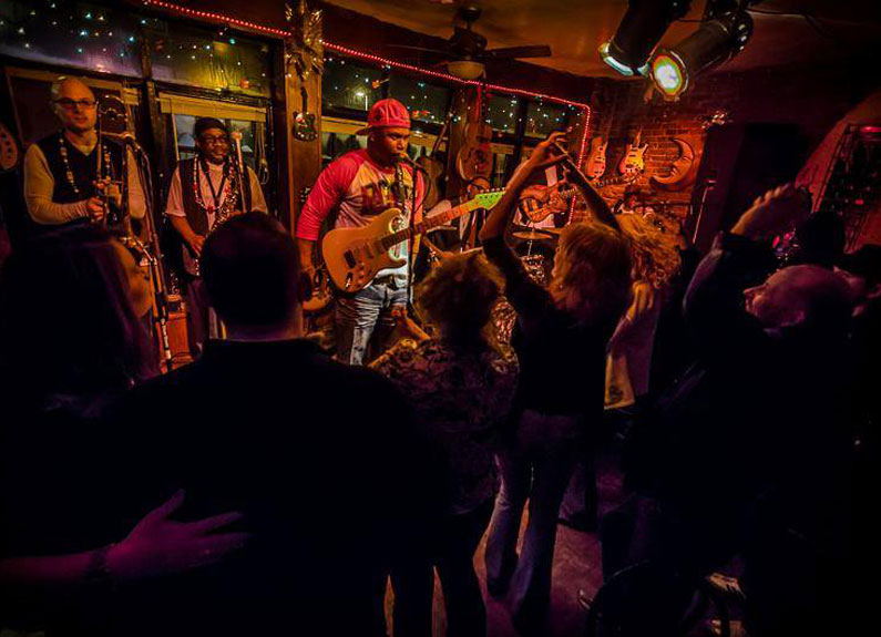 a blues band on a stage at a bar