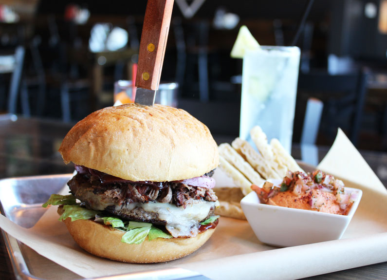 a burger with a steak knife sticking out of the top